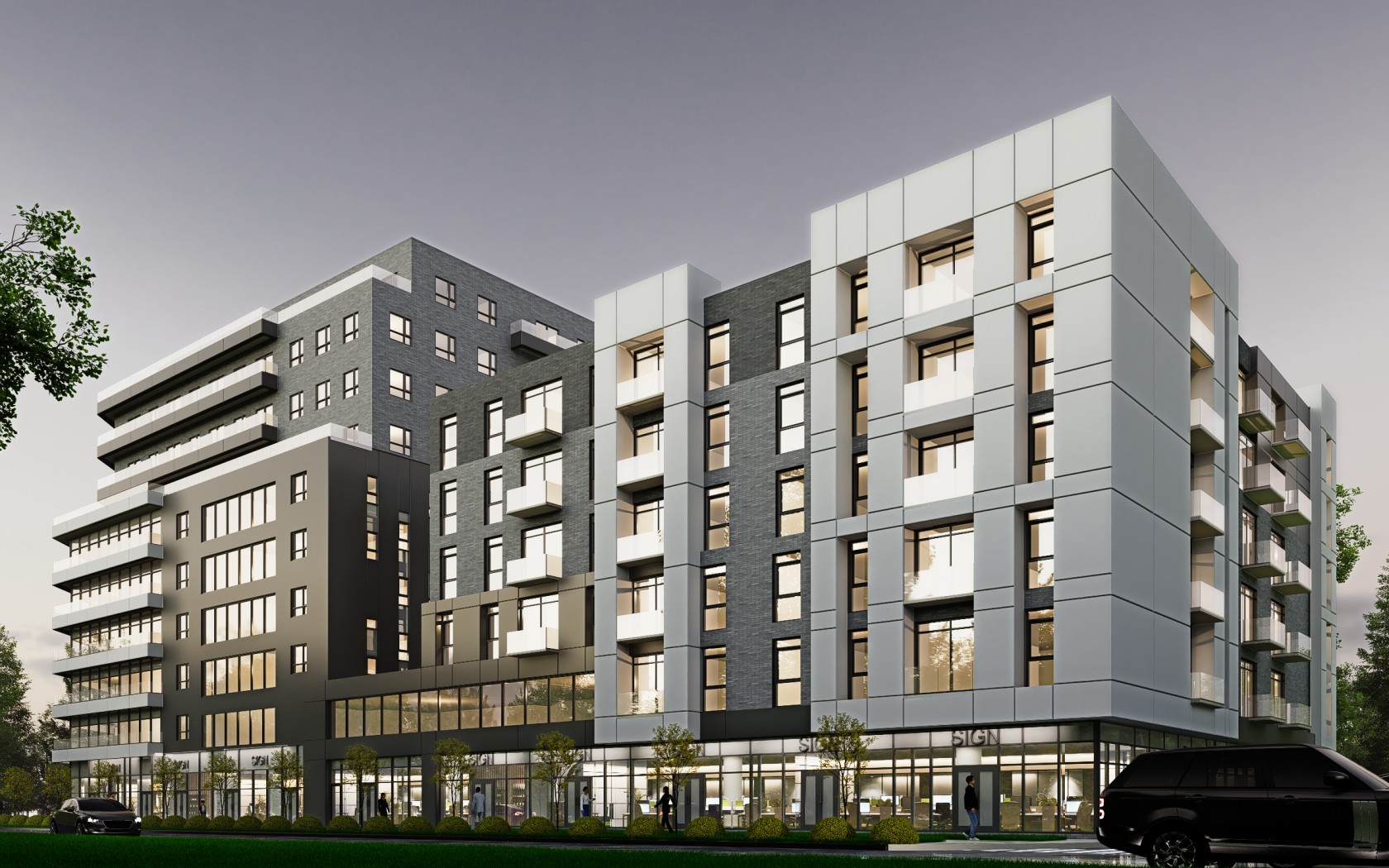 Modern multi-story apartment building with large windows, balconies, and ground-floor retail space, set against a dusk sky with greenery and parked cars in front.