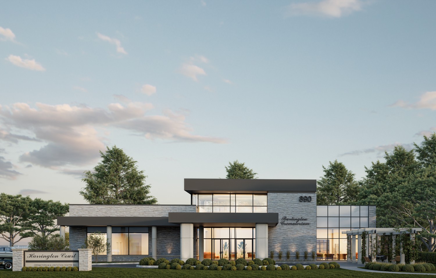 Modern two-story commercial building with large windows, surrounded by trees and landscaping, under a partly cloudy sky. A sign in front reads "Huntington Court.