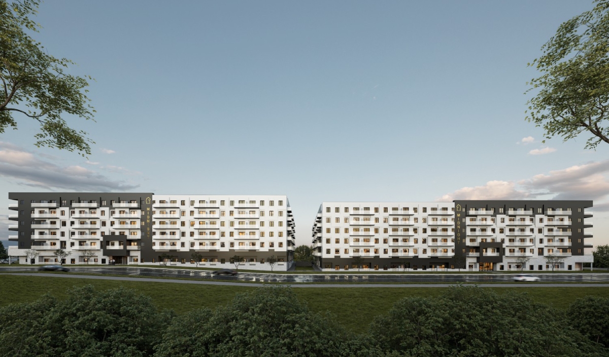 Two modern, symmetrical apartment buildings with multiple floors stand side by side, separated by trees, facing a road with several parked cars, under a clear sky.