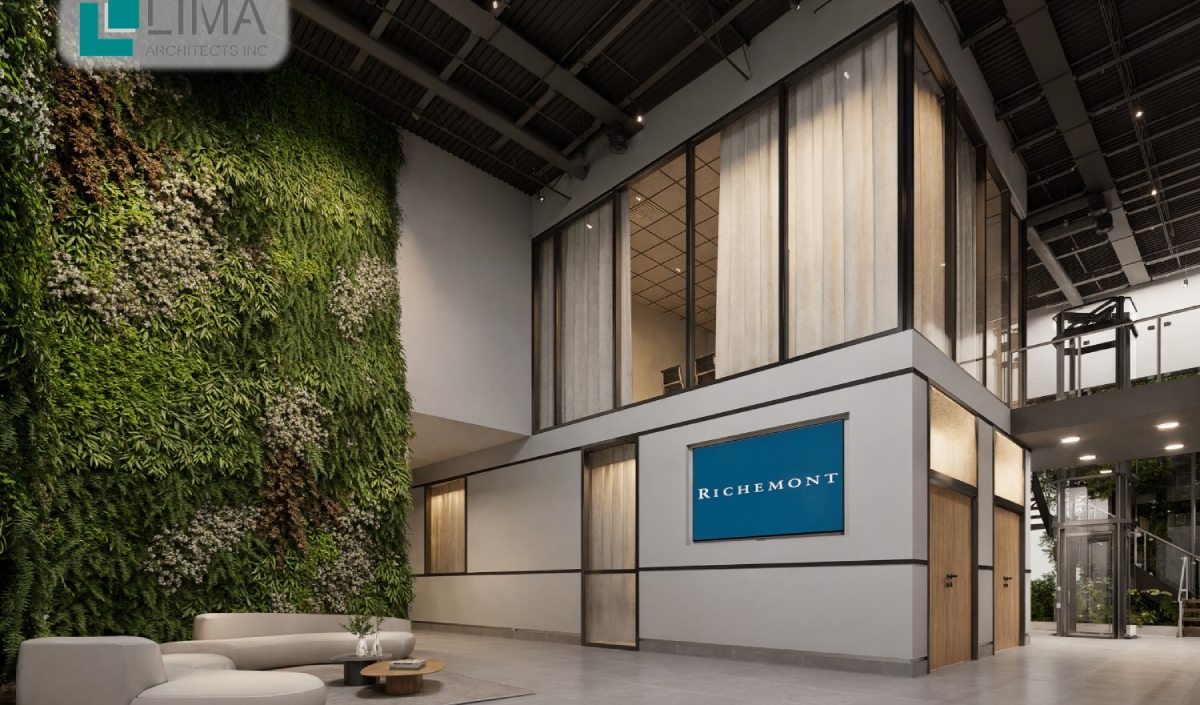 Modern office lobby with a green vertical garden, white sectional sofa, and a glass-walled mezzanine featuring a blue "RICHEMONT" sign on the wall.