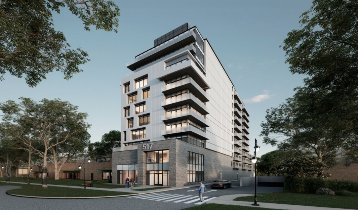 A modern mid-rise apartment building with white and gray exterior, large balconies, and ground-level entrance, located at 517, with people walking on the sidewalk and trees nearby.